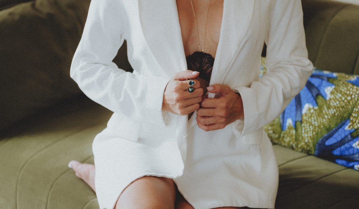 Femme assise en veste blanche portant un collier et une bague avec perle, photo portrait et mode en Guadeloupe par CW Photographe